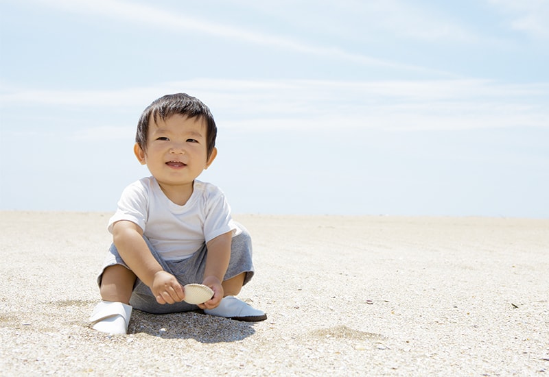赤ちゃんが砂遊びをする写真